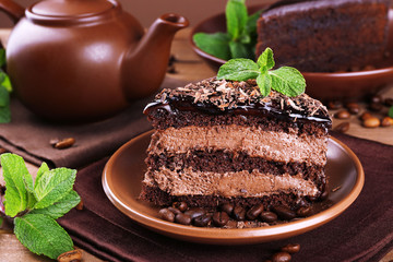Delicious chocolate cake with mint on plate on table close up