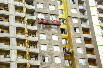 Tall building under construction and workers