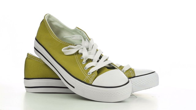 Yellow sneakers revolve on a white background