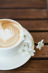 Fototapeta na wymiar Чашка кофе и цветок вишни