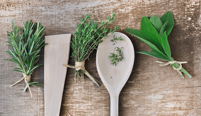 herbes aromatiques et cuillère en bois sur planche  © coco