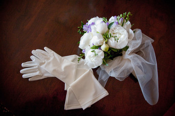 Guanti della sposa e bouquet di nozze su sfondo scuro