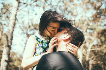 Young couple kissing outdoor in summer sun light.
