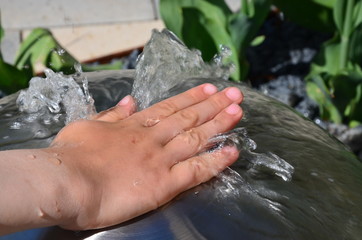 Kinderhand mit Springbrunnen