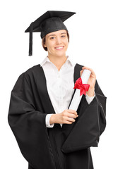 Woman in graduation gown posing with a diploma