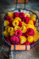 Colorful raspberries on wooden background