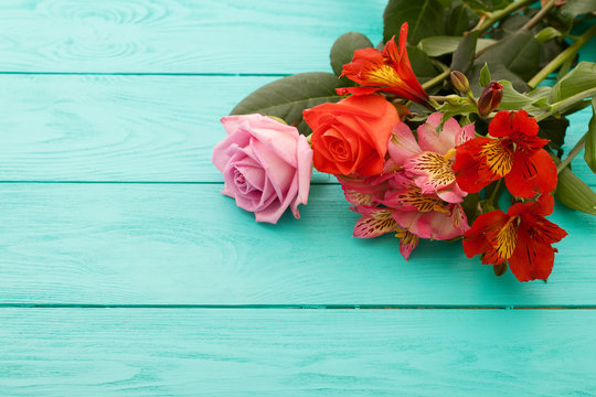 Fresh flowers on blue wooden background. Place for text. Selective focus