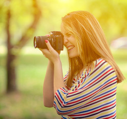 Portrait of beautiful laughing brunette girl taking photos at pa