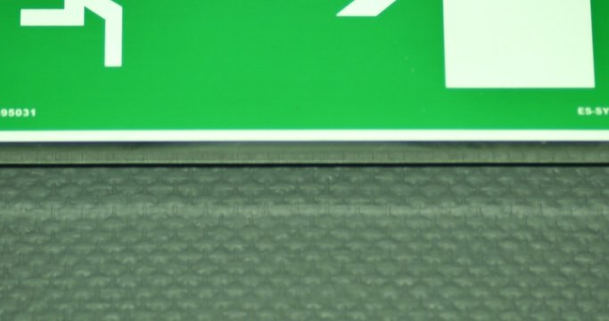 Footage of an exit sign-the shot moves from the bottom to the top