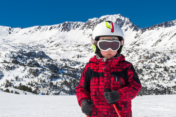 Fototapeta na wymiar Boy skiing at mountains in helmet and mask