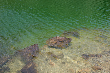 Klares Wasser im Bergsee mit Steinen