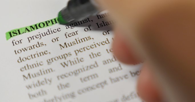 Close up of persons hand marking the word Islamophobia with a green marker