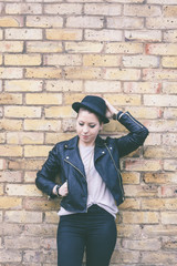 Fototapeta na wymiar Hipster woman portrait against a brick wall in London.