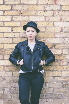 Hipster woman portrait against a brick wall in London.
