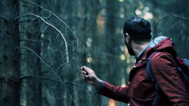 Young, frightened man running through the forest
