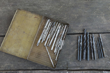Set of drill bits on an old wood background