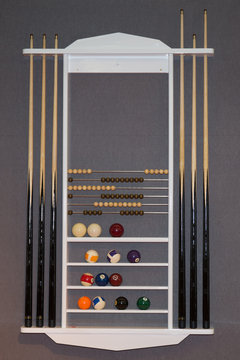 Top view of billiard balls and cues on grey background