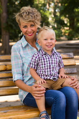 Boy with his mother sitting on the bench