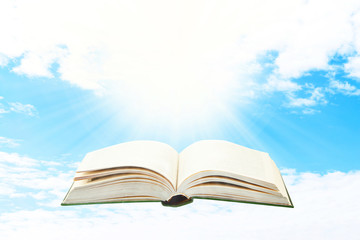 Opened book on sky background