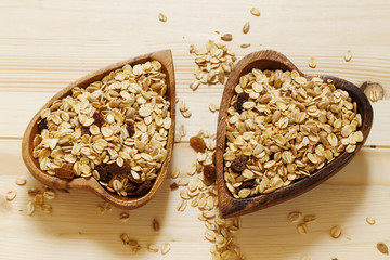 Homemade muesli in a bowl in the shape of a heart on a wooden ta