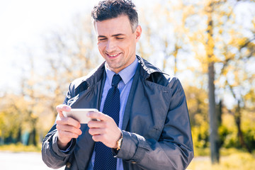 Fototapeta premium Happy businessman using smartphone