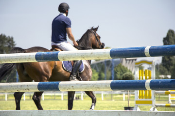 Rider jumping on horseback competing in equestrian tournament