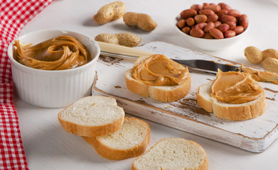 Toast with Peanut butter  and peanuts on a wooden board
