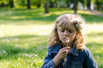 blond girl blowing dandelion