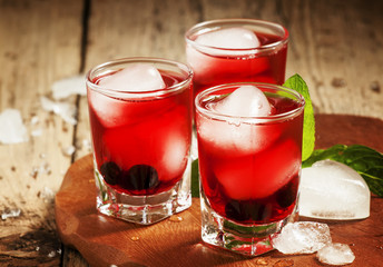 Red berry cocktail with mint and ice, selective focus