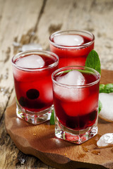 Red berry cocktail with mint and ice, selective focus