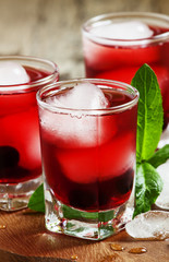 Red berry cocktail with mint and ice, selective focus