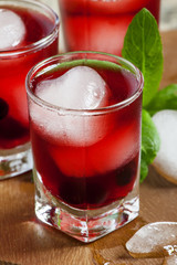 Red berry cocktail with mint and ice, selective focus