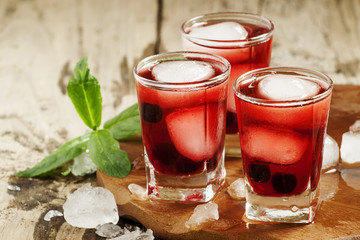 Red berry cocktail with mint and ice, selective focus