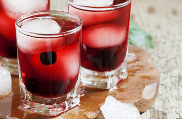 Red berry cocktail with mint and ice, selective focus