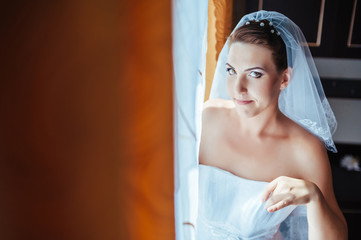 Fototapeta premium Bride getting ready. beautiful bride in white wedding dress with
