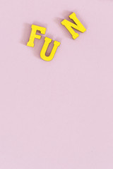 Words "love" & "hate" in yellow wooden letters on pink 
