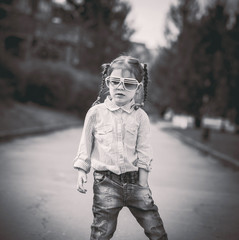 Little pretty girl walking on the city street