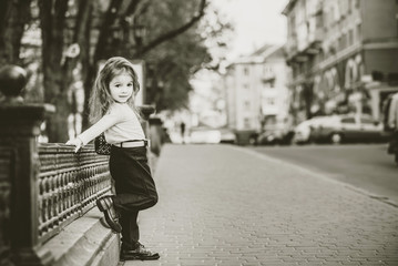 Little pretty girl walking on the city street