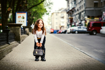 Little pretty girl walking on the city street