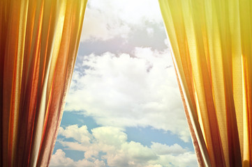 Window curtains with view of clouds and sky