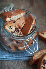 A glass jar and a handful of homemade biscotti with chocolate