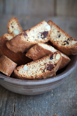 Homemade biscotti with chocolate and almonds in an old clay bowl