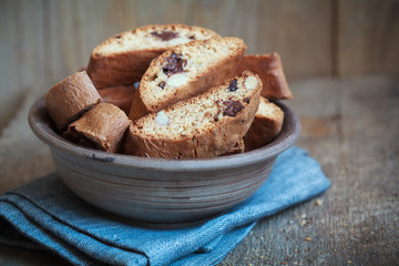 Homemade biscotti with chocolate and almonds in an old clay bowl