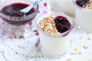 Small jar with homemade yogurt with blackcurrant jam and granola