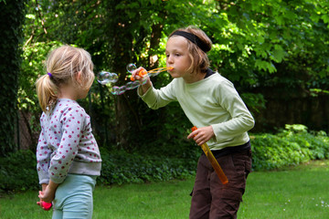 Kinder spielen mit Seifenblasen