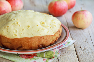 Apple sponge cake cooked in multicooker on a wooden table