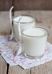 Two small jars homemade yogurt on a wooden table