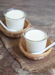 Two small jars homemade yogurt in a wicker baskets