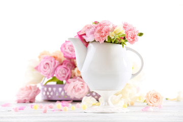 Obraz na płótnie Canvas Composition with beautiful spring flowers in teapot on light pink background