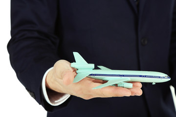 Businessman holding airplane model in hand, closeup
